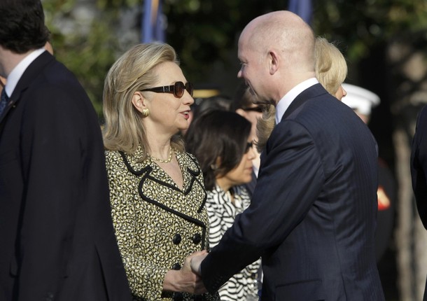 British Foreign Secretary William Hague (R) greets U.S. Secretary of State Hillary Clinton before an Official Arrival Ceremony for British Prime Minister David Cameron on the South Lawn of the White House in Washington