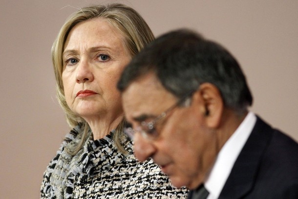 U.S. Secretary of State Clinton listens as U.S. Defense Secretary Panetta speaks during their news conference in Brussels