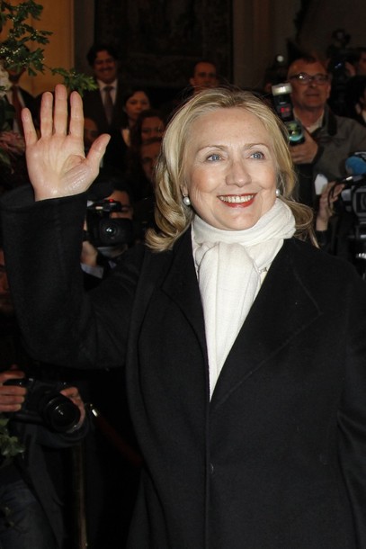 US Secretary of State Clinton waves upon her arrival to attend a meeting on Syria in Paris
