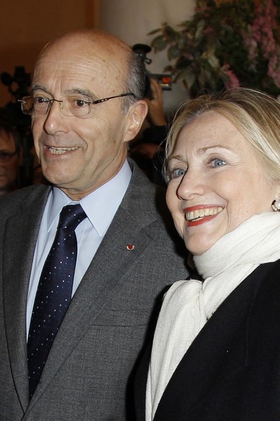 US Secretary of State Clinton is greeted by French Foreign Minister Juppe upon her arrival to attend a meeting on Syria in Paris