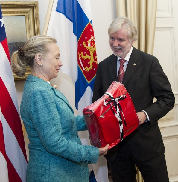 U.S. Secretary of State Hillary Rodham Clinton receives a gift from Finnish Foreign Minister Erkki Tuomioja, Wednesday, June 27, 2012, at the Government Banquet Hall in Helsinki, Finland. (AP Photo/Haraz N. Ghanbari, Pool)