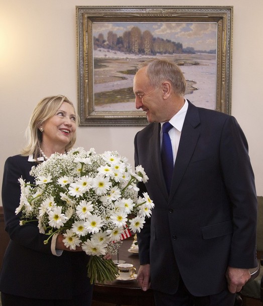 U.S. Secretary of State Hillary Rodham Clinton smiles after receiving a bouquet of flowers from Latvian President Andris Berzins before their meeting, Thursday, June 28, 2012, at the Riga Castle in Riga, Latvia. (AP Photo/Haraz N. Ghanbari, Pool)