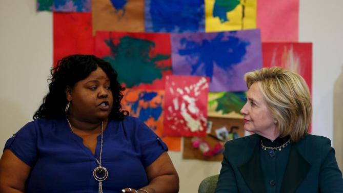 U.S. presidential candidate Hillary Clinton listens to Lakesia Collins speak at a roundtable discussion about childcare during a campaign stop in Chicago, Illinois, United States, May 20, 2015.    REUTERS/Jim Young