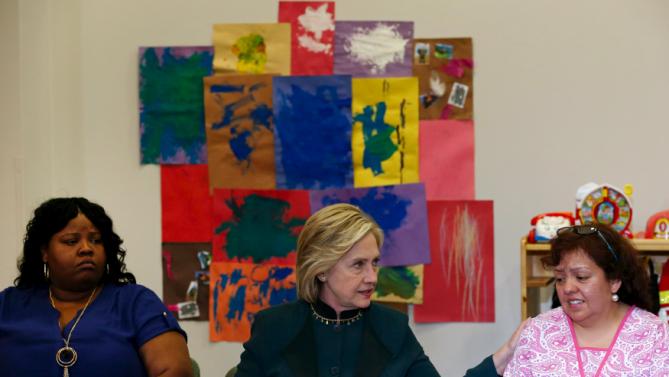 U.S. presidential candidate Hillary Clinton speaks at a roundtable discussion about childcare next to Lakesia Collins (L) and Maricarmen Macias during a campaign stop in Chicago, Illinois, United States, May 20, 2015.    REUTERS/Jim Young