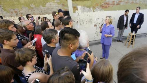 Democratic presidential candidate Hillary Rodham Clinton speaks to supporters in an overflow area outside a campaign stop at Uncle Nancy's Coffee House, Sunday, Sept. 6, 2015, in Newton, Iowa. (AP Photo/Charlie Neibergall)