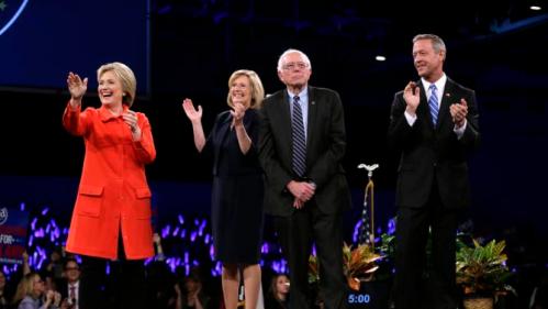 Democratic presidential candidates Hillary Rodham Clinton, left, Sen. Bernie Sanders, I-Vt., second from right, and former Maryland Gov. Martin O'Malley, right, stand on stage together at the start of the Iowa Democratic Party's Jefferson-Jackson Dinner, Saturday, Oct. 24, 2015, in Des Moines, Iowa. Iowa Democratic Party chair Andy McGuire, second from left, looks on. (AP Photo/Charlie Neibergall)