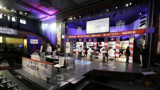 Workers stand at the podiums on stage during final preparations for Saturday night's Democratic presidential debate between Sen. Bernie Sanders, I-Vt,, Hillary Rodham Clinton and former Maryland Gov. Martin O'Malley, Friday, Nov. 13, 2015, in Des Moines, Iowa. (AP Photo/Charlie Neibergall)