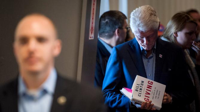 Former U.S. President Bill Clinton signs a book after his wife, Democratic U.S. presidential candidate Hillary Clinton's speech at the Central Iowa Democrats Fall Barbecue in Ames, Iowa November 15, 2015. REUTERS/Mark Kauzlarich