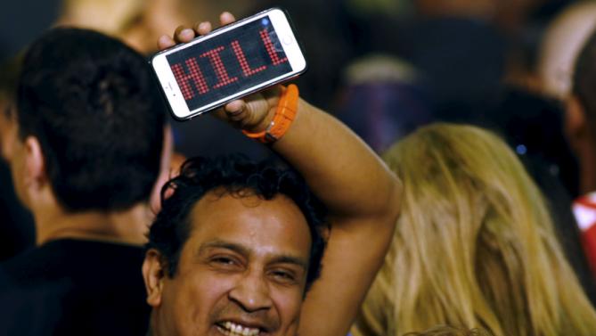 A man holds a cell phone with a message supporting Hillary Clinton who was set to speak at a Grassroots Organizing Event at Mountain View College in Dallas, Texas November 17, 2015.  REUTERS/Mike Stone