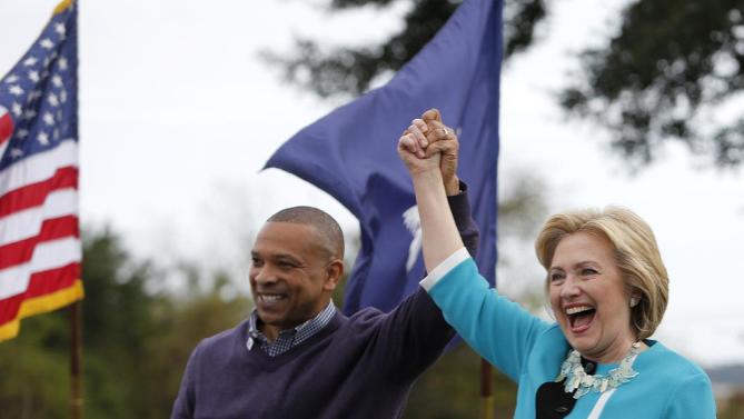 Democratic presidential candidate Hillary Rodham Clinton acknowledges the crowd at the Jenkins Orphanage in North Charleston, S.C., Saturday, Nov. 21, 2015, with S.C. State Sen. Marlon Kimpson during the Blue Jamboree event. (AP Photo/Mic Smith)
