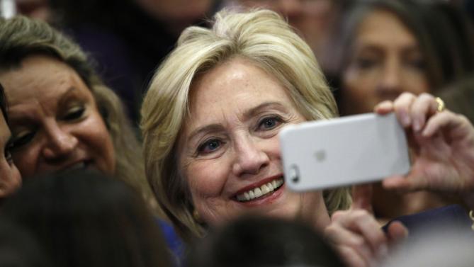 Democratic presidential candidate Hillary Rodham Clinton uses a supporter's mobile telephone to take a photograph after a rally Tuesday, Nov. 24, 2015, in a high school gymnasium in Denver. (AP Photo/David Zalubowski)