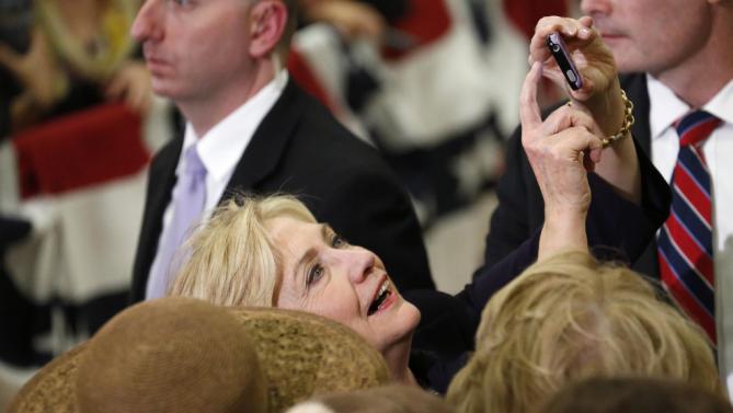 Democratic presidential candidate Hillary Rodham Clinton holds up a mobile telephone to take a photograph with a supporter while working a rope line following a rally Tuesday, Nov. 24, 2015, in a high school gymnasium in Denver. (AP Photo/David Zalubowski)