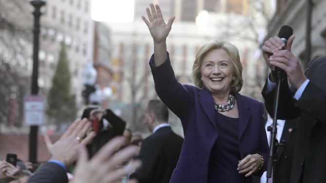 Democratic presidential candidate Hillary Clinton, right, waves to people in a crowd before a rally at Faneuil Hall, Sunday, Nov. 29, 2015, in Boston. Clinton and Boston Mayor Marty Walsh attended the event held to launch “Hard Hats for Hillary," a coalition to organize working families in construction, building, transportation, and other labor industries to support Clinton's agenda. (AP Photo/Steven Senne)
