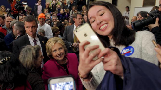 U.S. Democratic presidential candidate Hillary Clinton poses for a selfie with audience members at a campaign town hall meeting in Salem, New Hampshire December 8, 2015. REUTERS/Brian Snyder