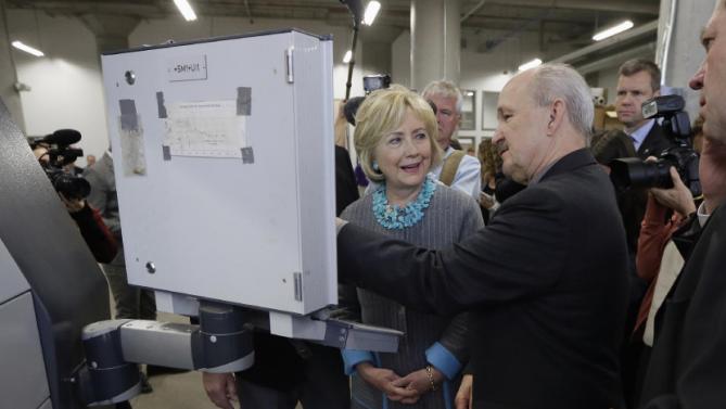 Democratic presidential candidate Hillary Clinton looks at a 3D printer as she tours the Cedar Valley TechWorks, Wednesday, Dec. 9, 2015, in Waterloo, Iowa. (AP Photo/Charlie Neibergall)