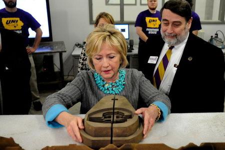 U.S. Democratic presidential candidate Hillary Clinton (C) looks at items made with a 3-D printer at Cedar Valley TechWorks in Waterloo, Iowa December 9, 2015. REUTERS/Mark Kauzlarich
