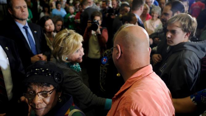 A supporter (L) of U.S. Democratic presidential candidate Hillary Clinton (R) leaves after greeting Clinton at a town hall in Waterloo, Iowa December 9, 2015. REUTERS/Mark Kauzlarich