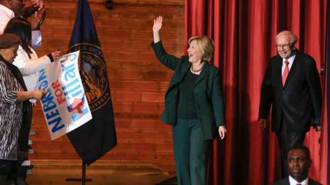 Democratic presidential candidate Hillary Clinton waves to supporters as she walks on stage accompanied by billionaire investor Warren Buffett, at a Grassroots Organizing Event in Omaha, Neb., Wednesday, Dec. 16, 2015. (AP Photo/Nati Harnik)