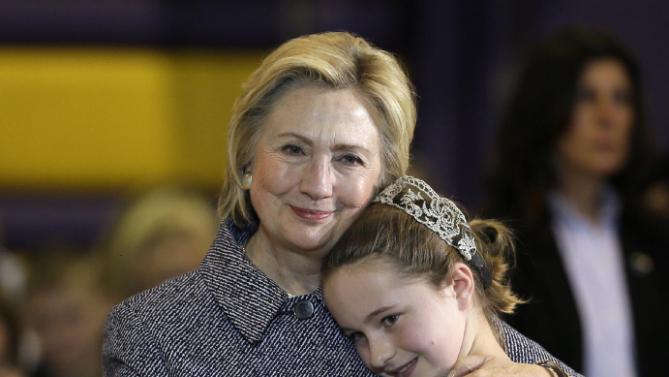 Democratic presidential candidate Hillary Clinton gets a hug from fifth-grader Hannah Tandy during a town hall meeting at Keota High School, Tuesday, Dec. 22, 2015, in Keota, Iowa. (AP Photo/Charlie Neibergall)