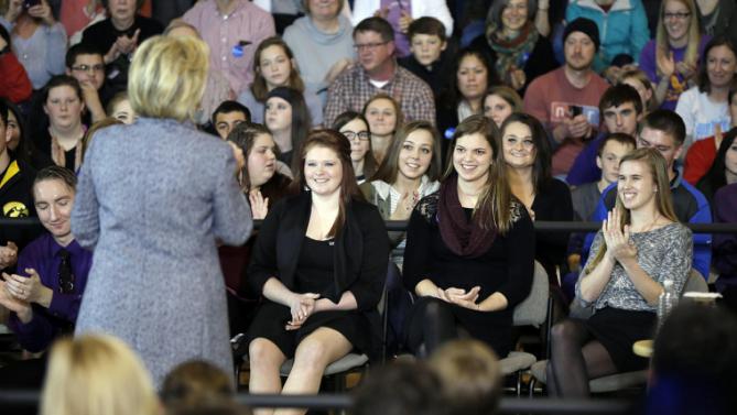 Students Kylea Tinnes, from left, Megan Adam and Abby Schulte listen as Democratic presidential candidate Hillary Clinton speaks during a town hall meeting at Keota High School, Tuesday, Dec. 22, 2015, in Keota, Iowa. (AP Photo/Charlie Neibergall)