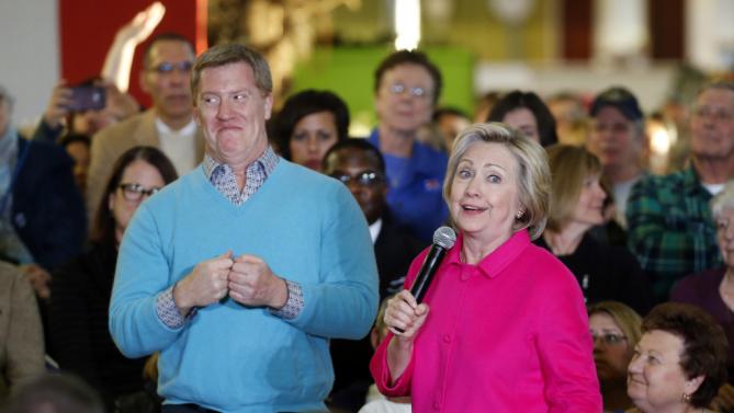 Democratic presidential candidate Hillary Clinton, right, and high school teacher David Swaney laugh about their colorful outfits before Swaney asks Clinton a question during a town hall at NewBo City Market in Cedar Rapids, Iowa, Monday, Jan. 4, 2016. (AP Photo/Patrick Semansky)