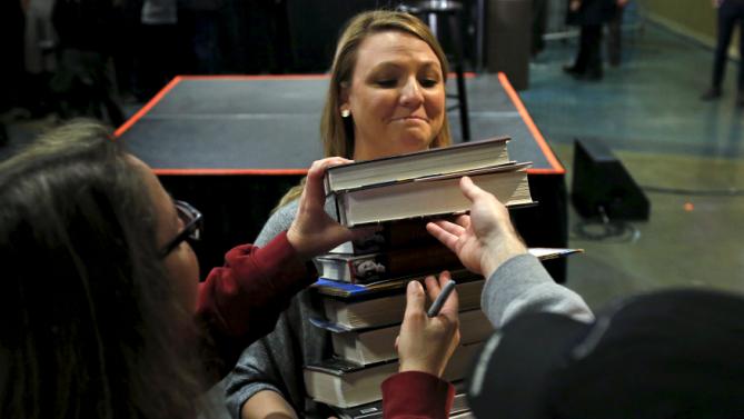 A campaign worker collects books from audience members to get them signed by U.S. Democratic presidential candidate Hillary Clinton at a rally in Council Bluffs, Iowa, United States, January 5, 2016. REUTERS/Jim Young