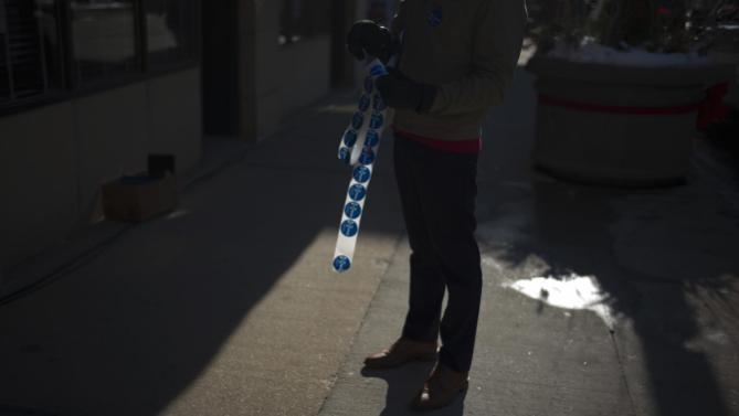 A volunteer holds campaign stickers outside the Orpheum Theatre in Sioux City, Iowa, Tuesday, Jan. 5, 2016, where Democratic presidential candidate Hillary Clinton is scheduled to host a rally. (AP Photo/Jae C. Hong)