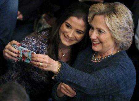 U.S. Democratic presidential candidate Hillary Clinton takes a "selfie" photograph with a supporter at a campaign event in Sioux City, Iowa, United States, January 5, 2016. REUTERS/Jim Young