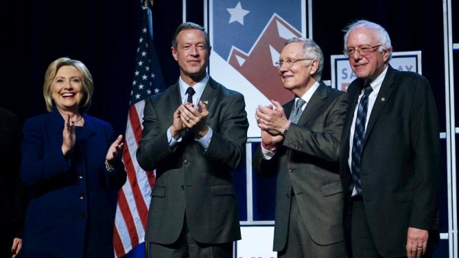 Democratic presidential candidates Hillary Clinton, Martin O'Malley (2nd L) and Bernie Sanders (R) applaud on stage with Sen. Harry Reid (D-NV) at a Democratic fundraising dinner in Las Vegas, Nevada, January 6, 2016.  REUTERS/Rick Wilking