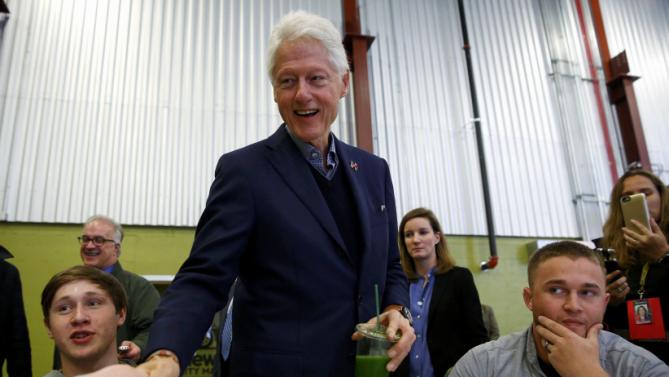 Former U.S. President Bill Clinton (C) greets customers and employees while campaigning for his wife, Democratic presidential candidate Hillary Clinton, at the NewBo Market in Cedar Rapids, Iowa, January 7, 2016. REUTERS/Aaron P. Bernstein