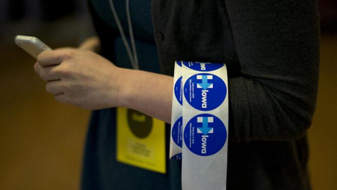 A volunteer carries a roll of campaign stickers for Democratic presidential candidate Hillary Clinton Monday, Jan. 11, 2016, in Waterloo, Iowa. (AP Photo/Jae C. Hong)