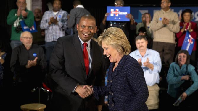 Democratic presidential candidate Hillary Clinton shares a laugh with Transportation Secretary Anthony Foxx during a rally, Monday, Jan. 11, 2016, in Waterloo, Iowa. (AP Photo/Jae C. Hong)