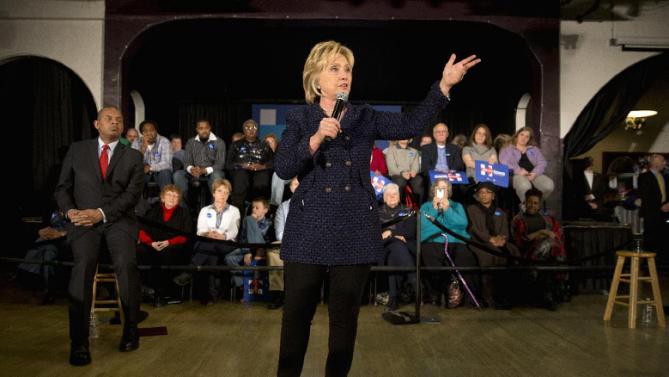 Transportation Secretary Anthony Foxx listens at left, as Democratic presidential candidate Hillary Clinton speaks at a campaign rally, Monday, Jan. 11, 2016, in Waterloo, Iowa. (AP Photo/Jae C. Hong)