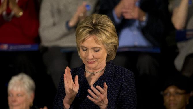 Democratic presidential candidate Hillary Clinton applauds while listening to Transportation Secretary Anthony Foxx at a rally Monday, Jan. 11, 2016, in Waterloo, Iowa. (AP Photo/Jae C. Hong)