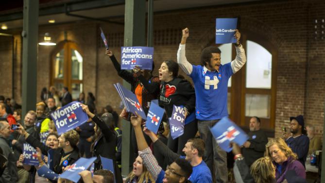 Supporters wave signs and shout while they wait for Democratic presidential candidate Hillary Rodham Clinton to arrive at the Jim Clyburn Fish Fry, on Saturday, Jan. 16, 2016, at the Charleston Visitor Center in Charleston, S.C. (AP Photo/Stephen B. Morton)