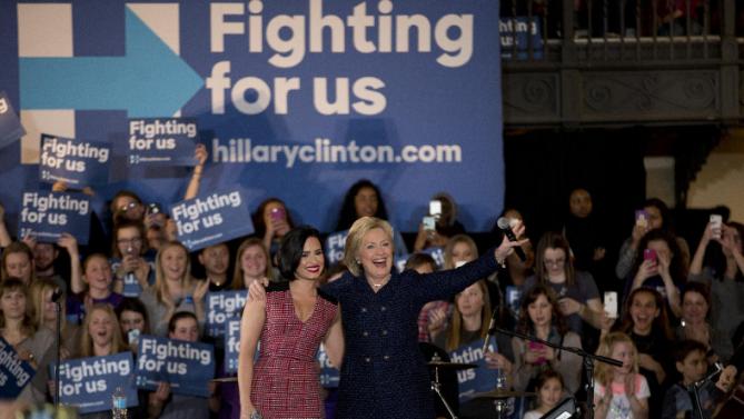 Democratic presidential candidate Hillary Clinton, right, and musician Demi Lovato acknowledge the cheering crowd at a rally on the campus of University of Iowa Thursday, Jan. 21, 2016, in Iowa City, Iowa. (AP Photo/Jae C. Hong)