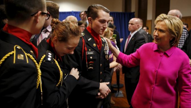 Democratic U.S. presidential candidate Hillary Clinton takes photos with the color guard during the Scott County Democratic Party's Red, White and Blue Dinner at the Mississippi Valley Fairgrounds in Davenport, Iowa, January 23, 2016. REUTERS/Scott Morgan