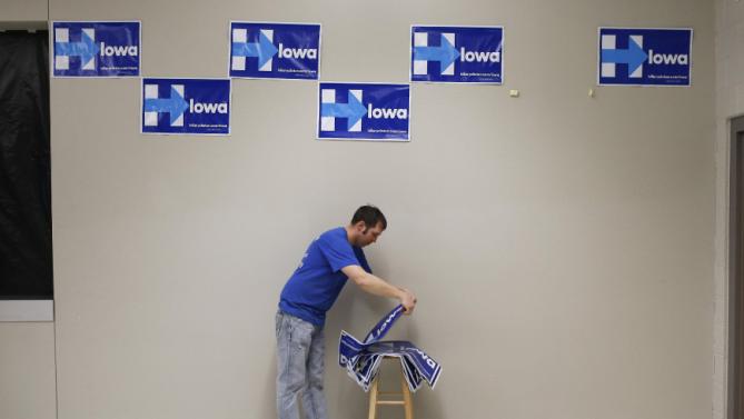 Shawn Stender removes campaign signs for Democratic presidential candidate Hillary Clinton after a town hall featuring Clinton at Vernon Middle School in Marion, Iowa, Sunday, Jan. 24, 2016. (AP Photo/Patrick Semansky)