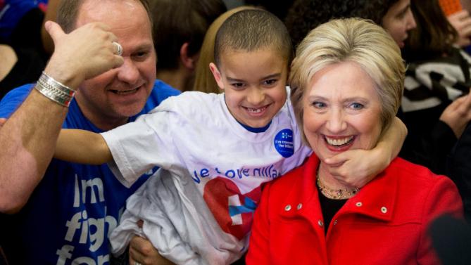 Democratic presidential candidate Hillary Clinton is embraced by a young member of the audience as they pose for a photograph at a rally at Washington High School in Cedar Rapids, Iowa, Saturday, Jan. 30, 2016. (AP Photo/Andrew Harnik)