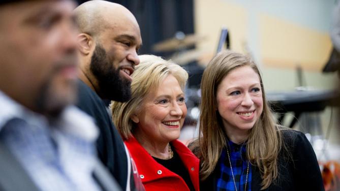 Democratic presidential candidate Hillary Clinton, center, and her daughter Chelsea Clinton, right, pose for a photograph with visitors to the African American Festival, I'll Make Me a World Celebration Day at the Iowa Events Center in Des Moines, Iowa, Saturday, Jan. 30, 2016. (AP Photo/Andrew Harnik)
