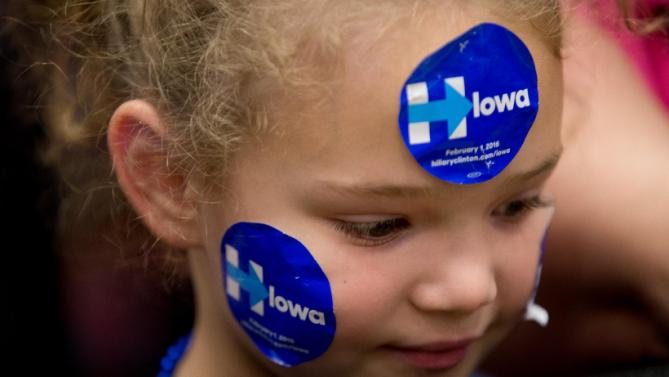 A young member of the audience wears campaign stickers before Democratic presidential candidate Hillary Clinton, accompanied by former President Bill Clinton and their daughter Chelsea Clinton, arrive to speak at a rally at Washington High School in Cedar Rapids, Iowa, Saturday, Jan. 30, 2016. (AP Photo/Andrew Harnik)