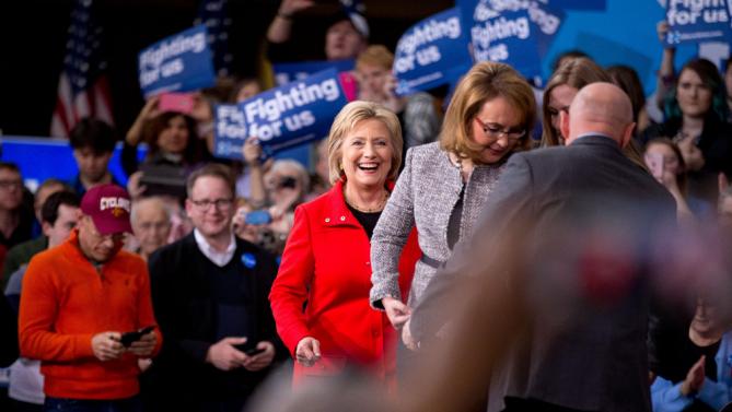 Democratic presidential candidate Hillary Clinton, center, accompanied by former Arizona Rep. Gabby Giffords, second from right, and her husband Mark Kelly, right, arrives for a rally at Iowa State University in Ames, Iowa Saturday, Jan. 30, 2016(AP Photo/Andrew Harnik)