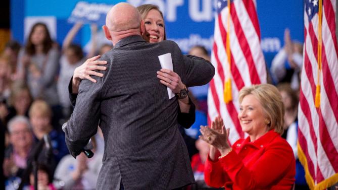 Democratic presidential candidate Hillary Clinton, right, applauds as her daughter Chelsea Clinton, who gets a hug from Mark Kelly, left, during a rally at Iowa State University in Ames, Iowa Saturday, Jan. 30, 2016.  (AP Photo/Andrew Harnik)