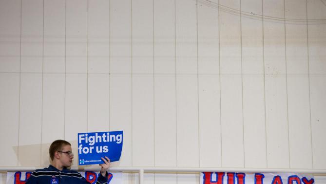 A member of the audience holds a campaign sign at the top of a set of bleachers as Democratic presidential candidate Hillary Clinton speaks at a rally at Washington High School in Cedar Rapids, Iowa, Saturday, Jan. 30, 2016. (AP Photo/Andrew Harnik)