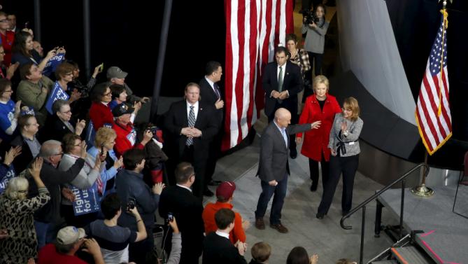 U.S. Democratic presidential candidate Hillary Clinton (C), in red, arrives to a campaign rally with Gabby Giffords (R) and her husband Mark Kelly (L) at Iowa State University in Ames, Iowa January 30, 2016. REUTERS/Adrees Latif