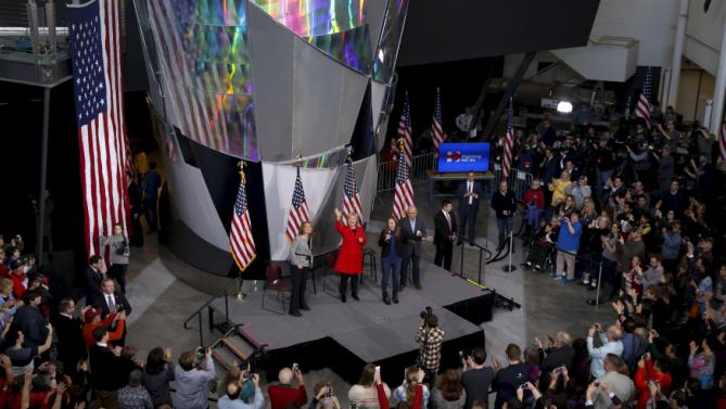 U.S. Democratic presidential candidate Hillary Clinton (C), in red, waves after arriving to campaign rally with daughter Chelsea Clinton, Gabby Giffords (L) and her husband Mark Kelly (R) during a campaign rally at Iowa State University in Ames, Iowa January 30, 2016. REUTERS/Adrees Latif