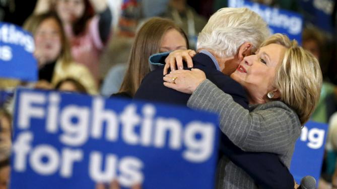 U.S. Democratic presidential candidate Hillary Clinton embraces former U.S. President Bill Clinton as daughter Chelsea Clinton looks on during a campaign rally at Abraham Lincoln High School in Des Moines, Iowa January 31, 2016.  REUTERS/Adrees Latif