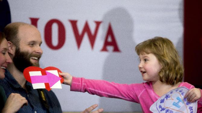 Magnolia Mandelko, 5, excitedly holds a campaign card and a drawing as she waits for Democratic presidential candidate Hillary Clinton, accompanied by her daughter Chelsea Clinton, to arrive at a rally at Abraham Lincoln High School in Council Bluffs, Iowa, Sunday, Jan. 31, 2016. (AP Photo/Andrew Harnik)