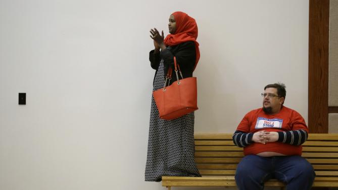 Fatuma Hersi, left, and Jeremy Bernstein, both of Des Moines, Iowa, listen as Democratic presidential candidate Hillary Clinton speaks during a campaign rally at the Iowa State Historical Museum, Monday, Jan. 4, 2016, in Des Moines, Iowa. (AP Photo/Charlie Neibergall)