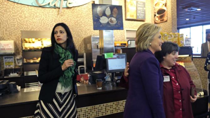 Huma Abedin, left, aide to Democratic presidential candidate Hillary Clinton, right, waits as she poses for a photo with an employee at Market Basket Supermarket, Tuesday, Feb. 2, 2016, in Manchester, N.H. (AP Photo/Elise Amendola)